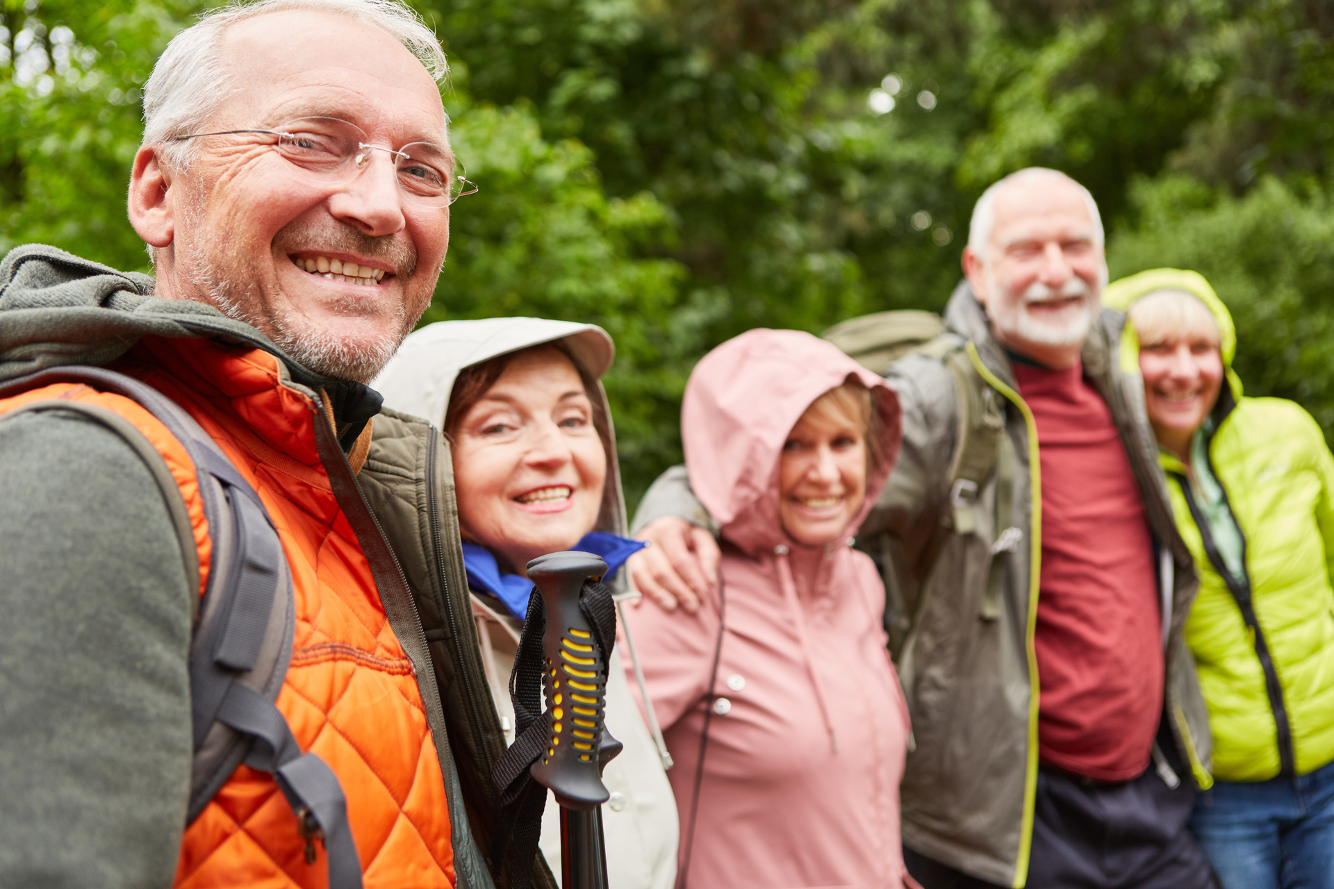 Des amis âgés heureux, hommes et femmes, faisant une randonnée dans la forêt.